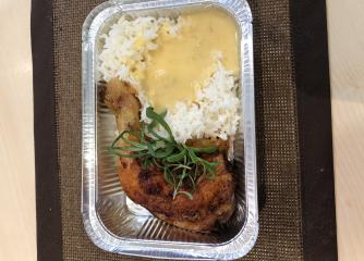 En lunchmåltid med ris och kyckling i en lunchlåda
