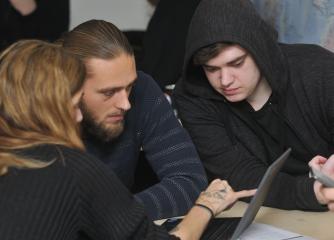 Tre personer tittar tillsammans på en datorskärm
